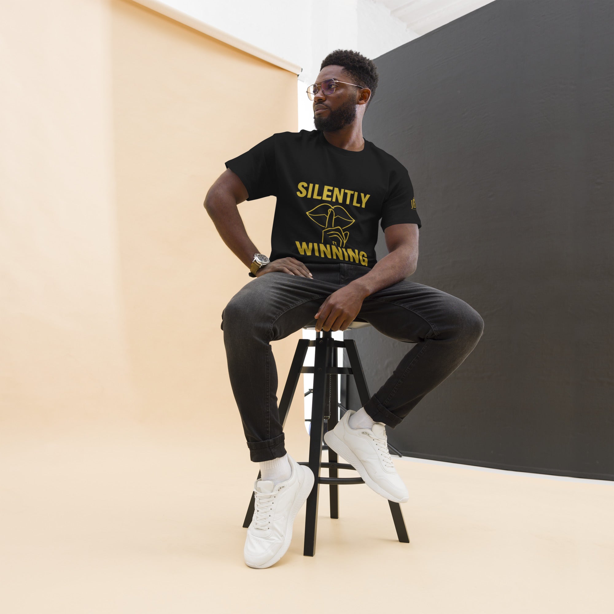 Black Silently Winning unisex t-shirt with bold gold lettering on front. Luxury faith streetwear symbolizing perseverance and quiet strength.