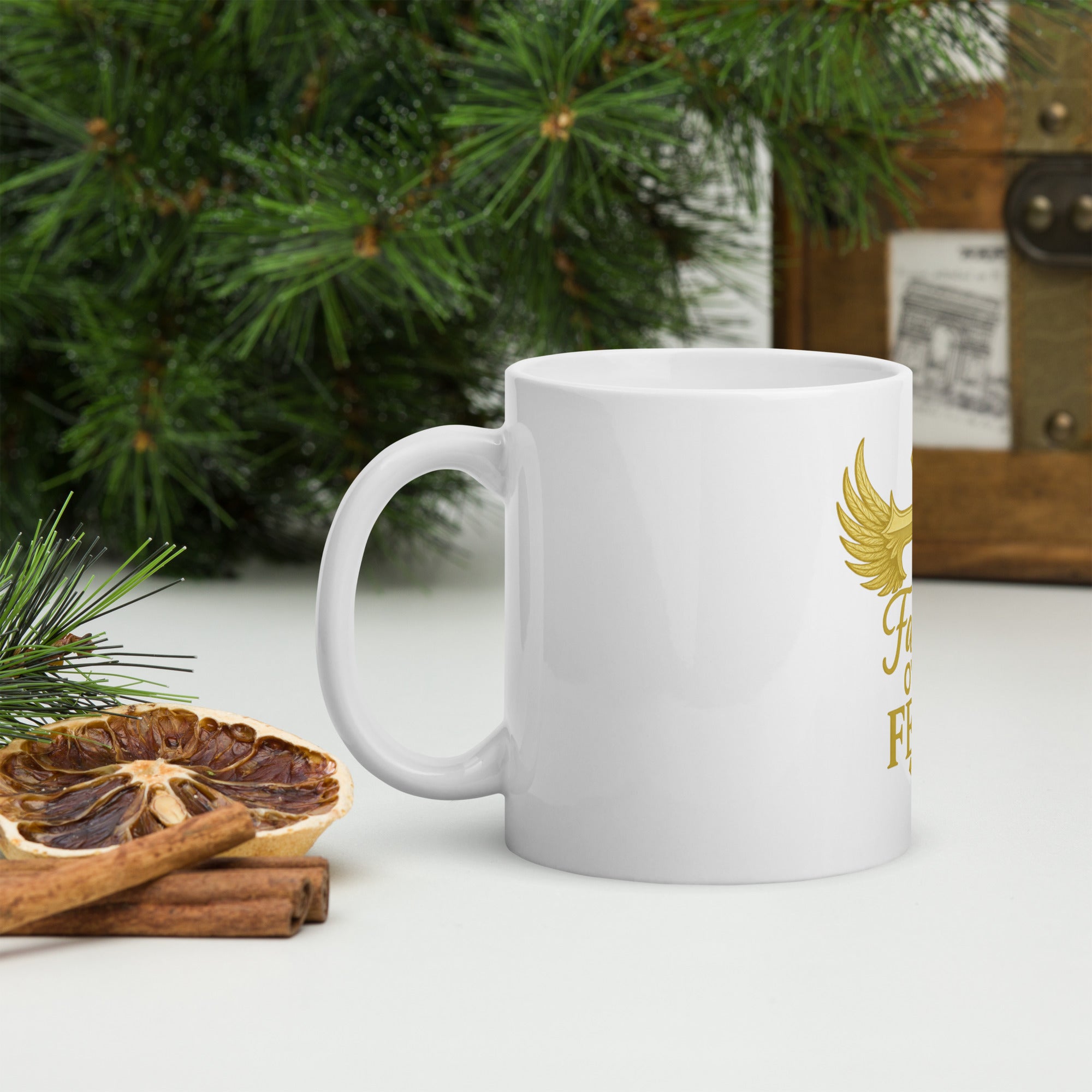 "Faith Over Fear mug with gold cross and wings design, displayed from a different angle."