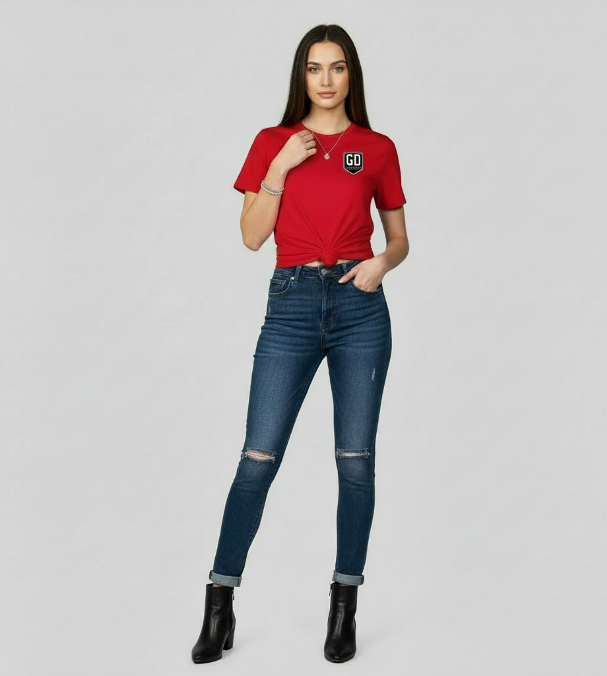 Side view of woman wearing red JBI fitted tee and jeans.”