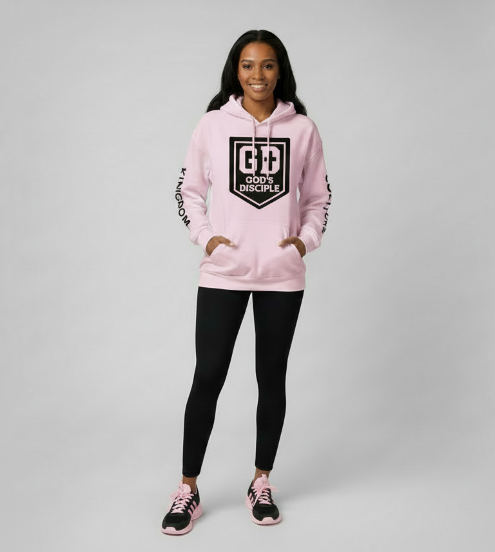 Woman wearing pink God’s Disciple hoodie, full-body studio shot