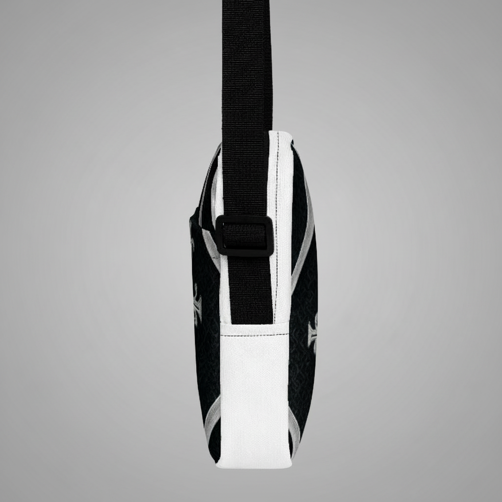 “Side profile of black and white Kingdom Luxe crossbody bag with geometric cross pattern and black strap.”