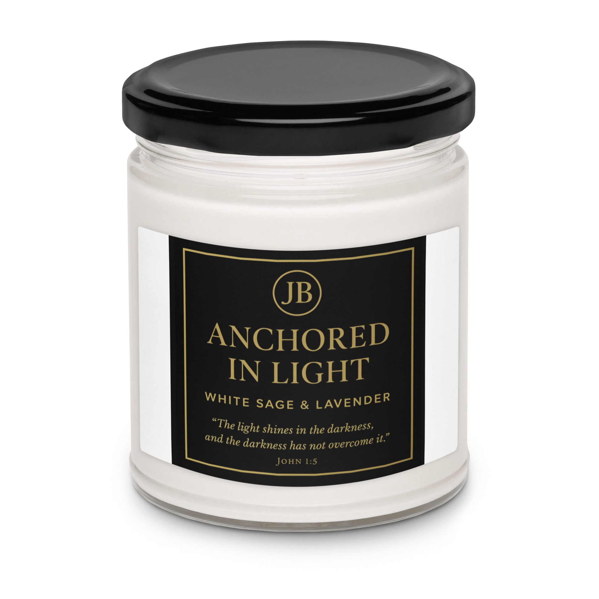 “Single ‘Anchored in Light’ candle with black lid, featuring a sleek black and gold label with scripture John 1:5. White Sage & Lavender scent in a clear glass jar, centered on a white background for a minimal, luxury presentation.”