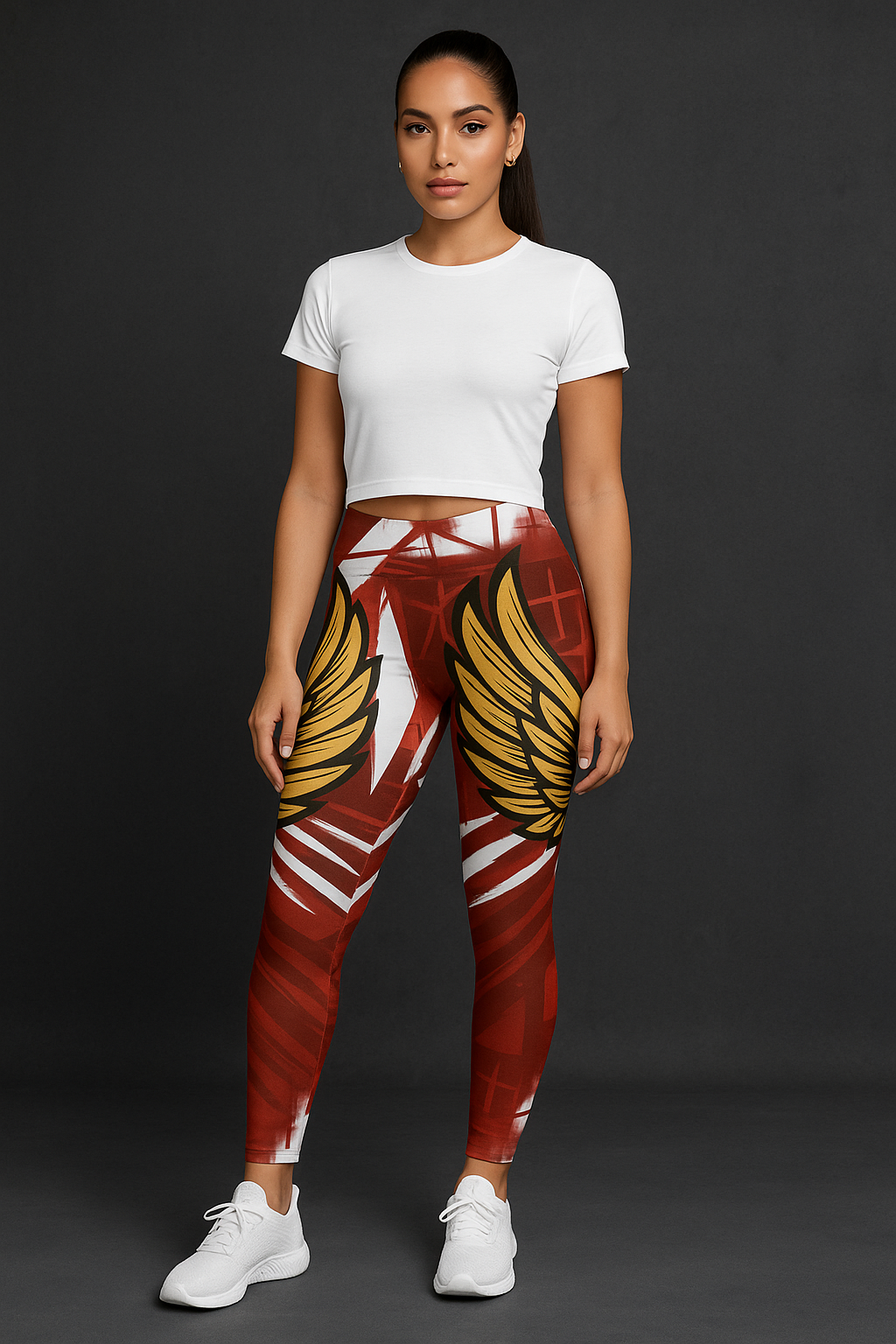 Female model wearing Wings of Victory Leggings in burgundy with gold wing graphics, styled with white crop top.